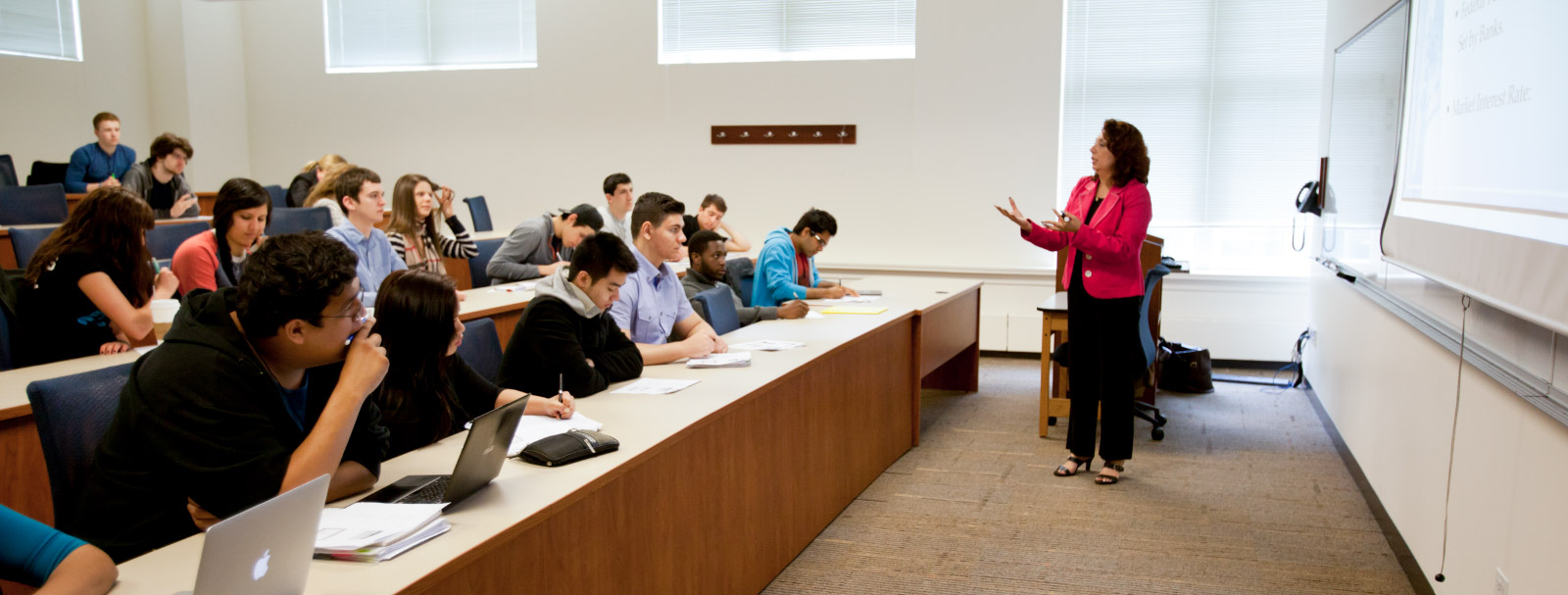 Caucasian professor lecturing in front of rows of students