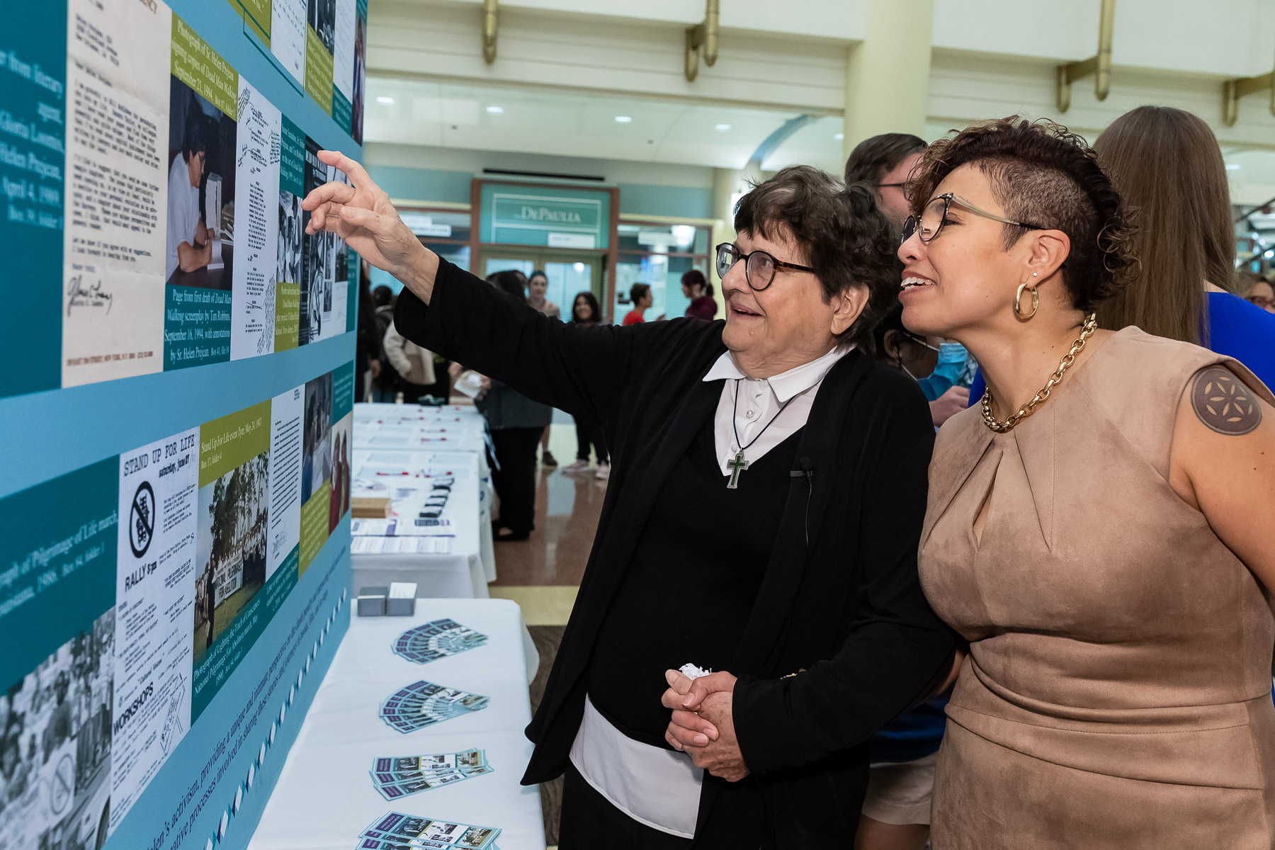 Sister Helen Prejean, C.S.J., points to a display, accompanied by Georgianna Torres Reyes.