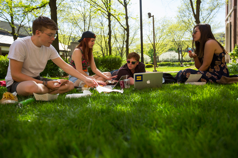 Students sitting in the Quad while reviewing class notes