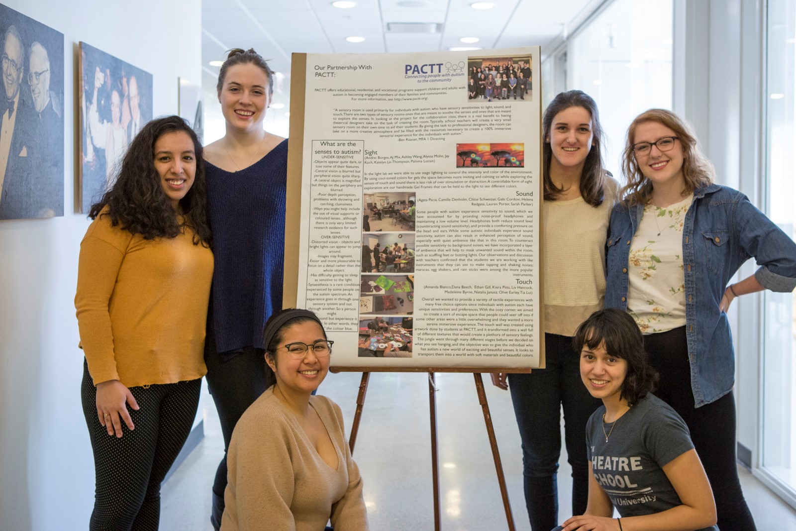 A group of students displaying their poster on community-based service learning