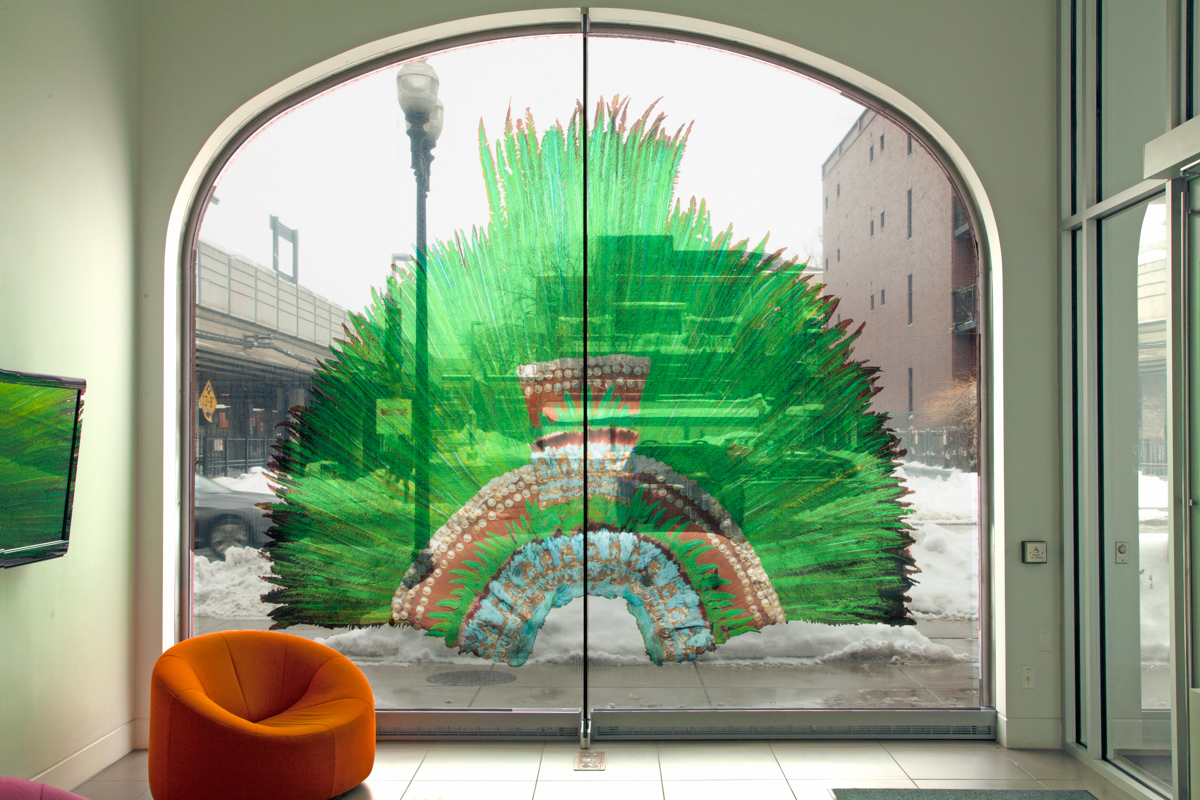 Image of green headress displayed in arched window
