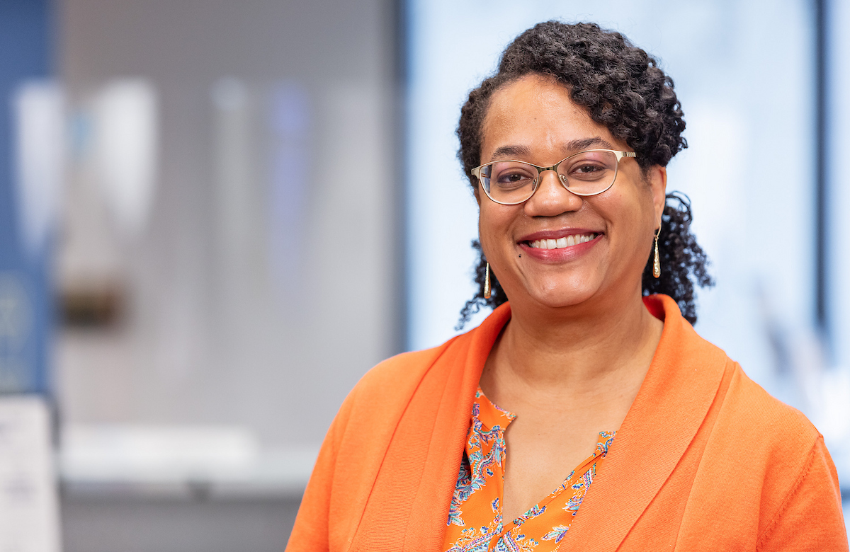 Brenda Williams wearing glasses and an orange blazer