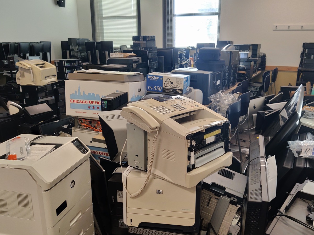 piles of electronic devices in a classroom