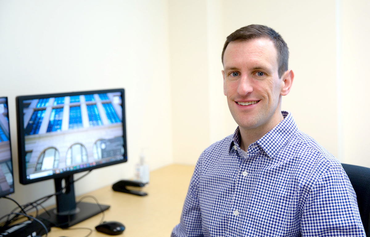 Tom Longo sits in front of computer monitors