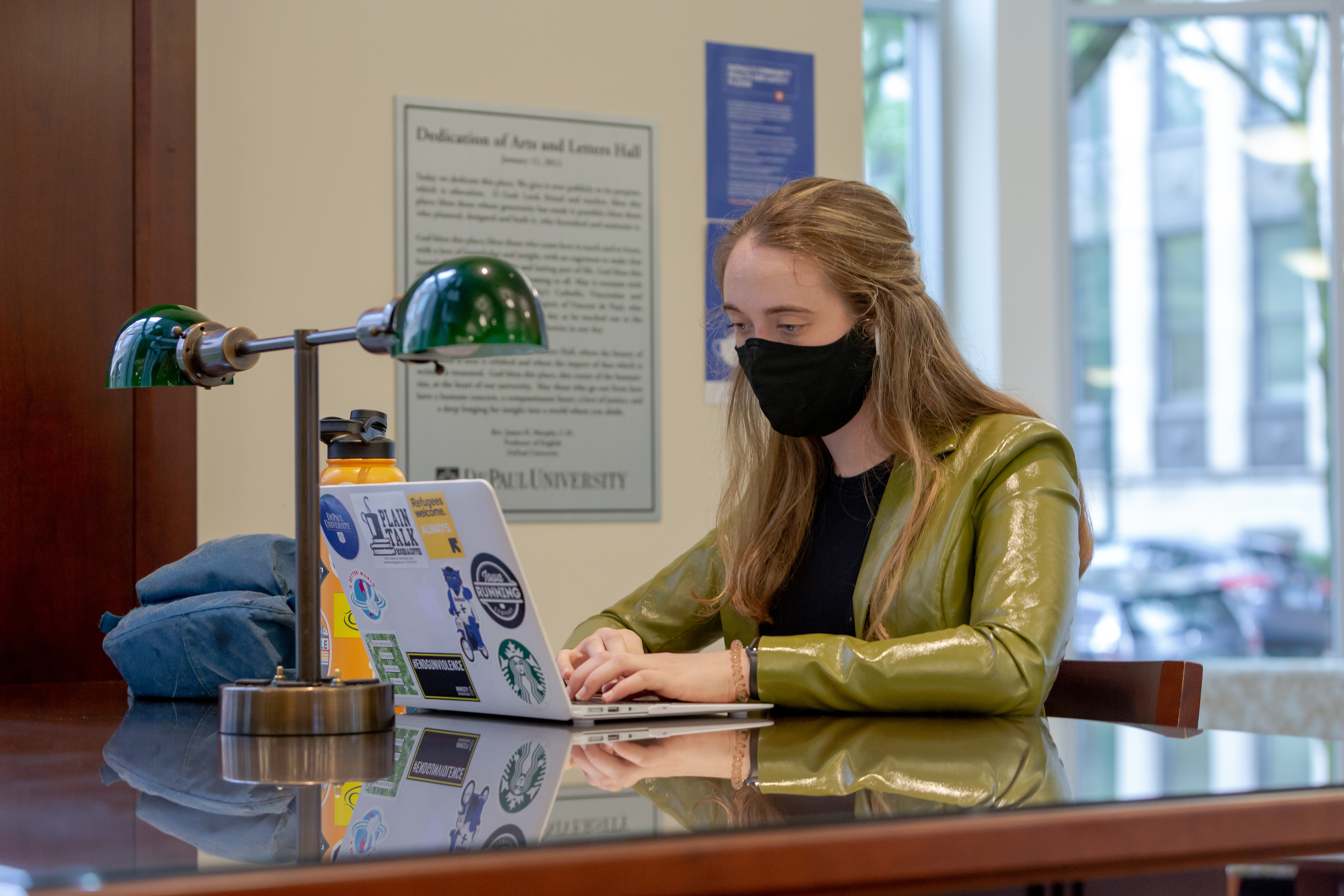Female student wearing a mask on a laptop
