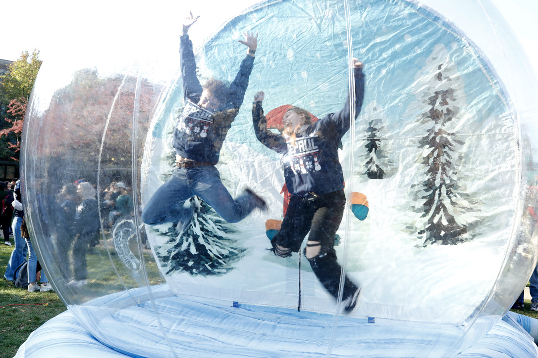 Students posed for pictures in a giant snowglobe bounce house during the 2022 Ugly Sweater Party. (DePaul University/Tom Vangel)