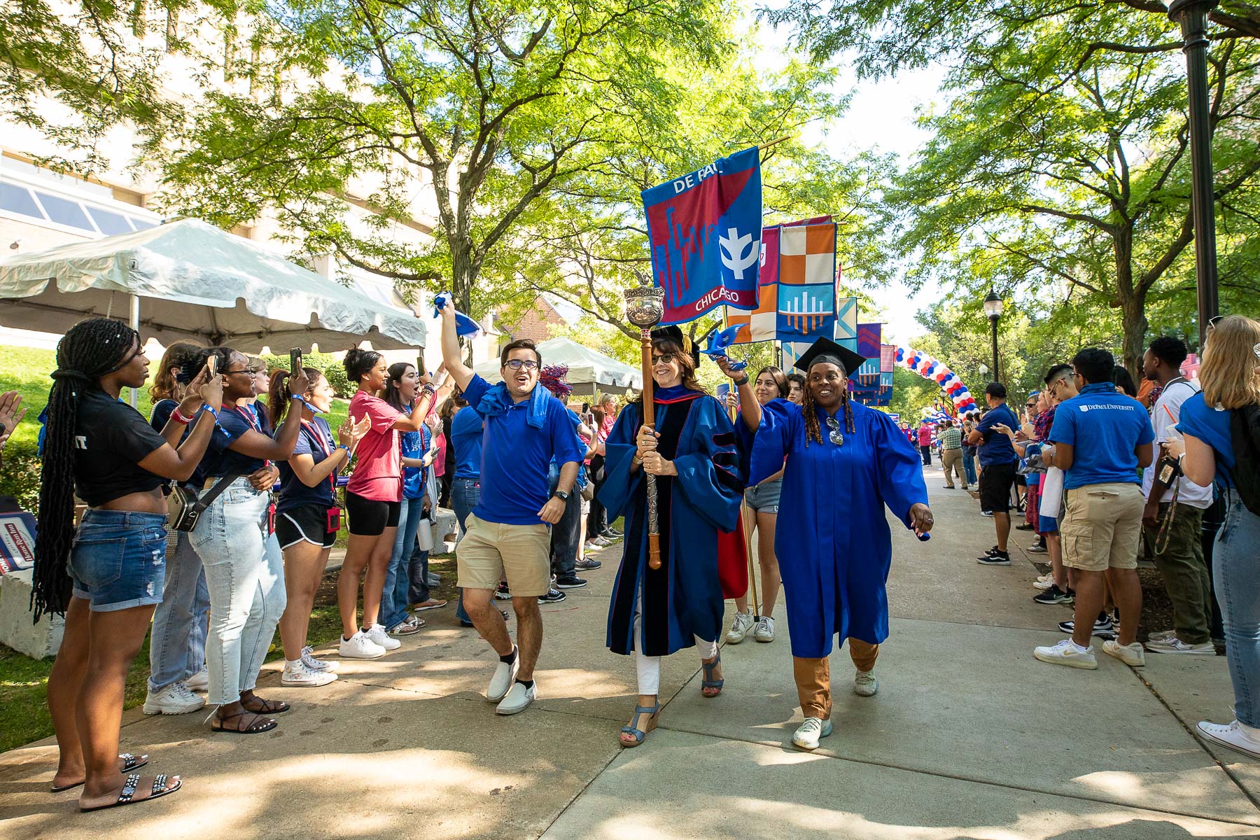 Left to right, Kevin Holechko, SGA president, Sonia Soltero, Faculty Council president, and Dani Blackwell, Staff Council vice president, carry the university mace into the Quad during the new student cavalcade. (DePaul University/Jeff Carrion)