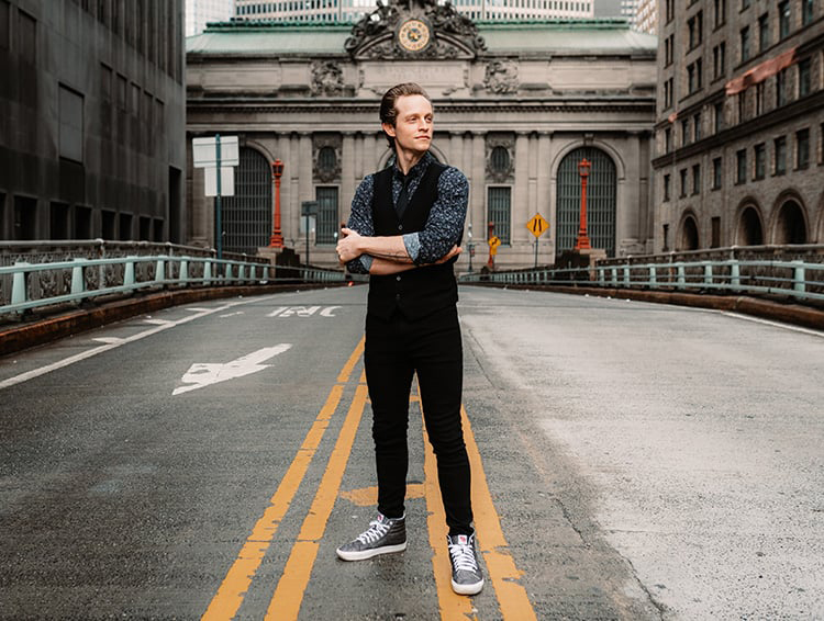 Brenton Ryan stands in the street with arms crossed