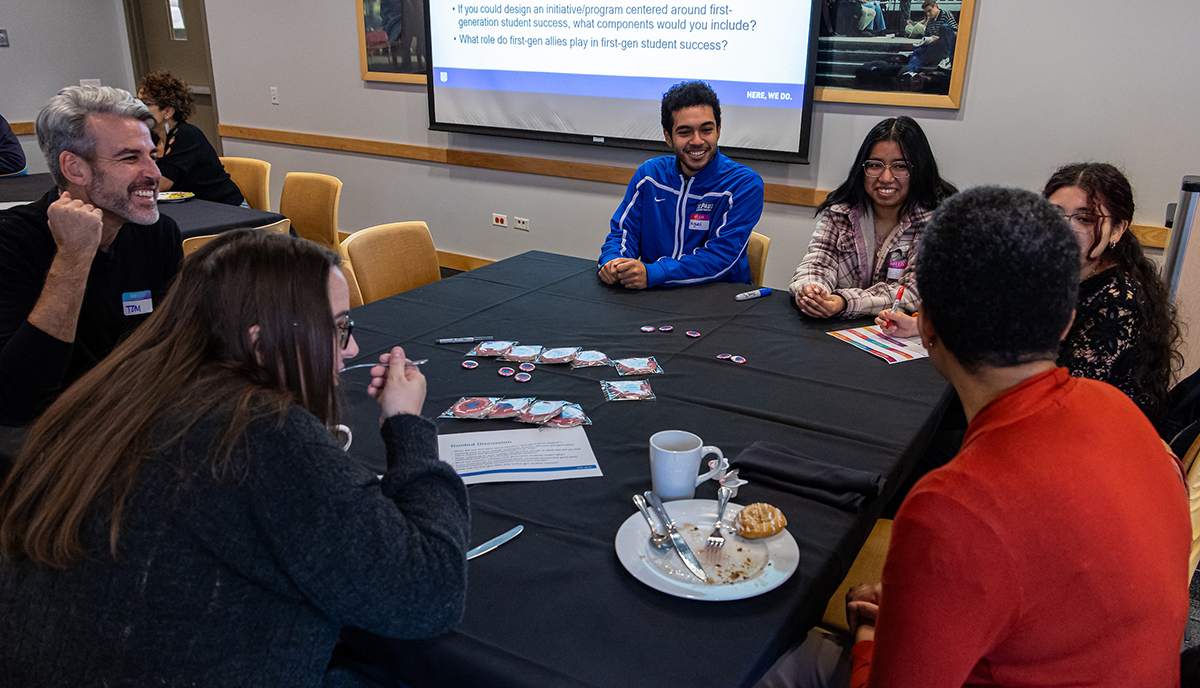 Attendees sit around a table talking at the 2023 I Am F1rst Breakfast