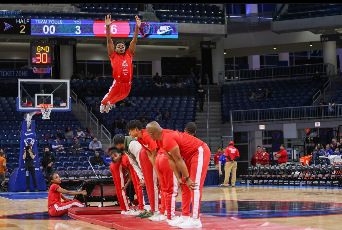 Jamari Grant soars through the air at a DePaul basketball game as part of the Jesse White Tumblers.