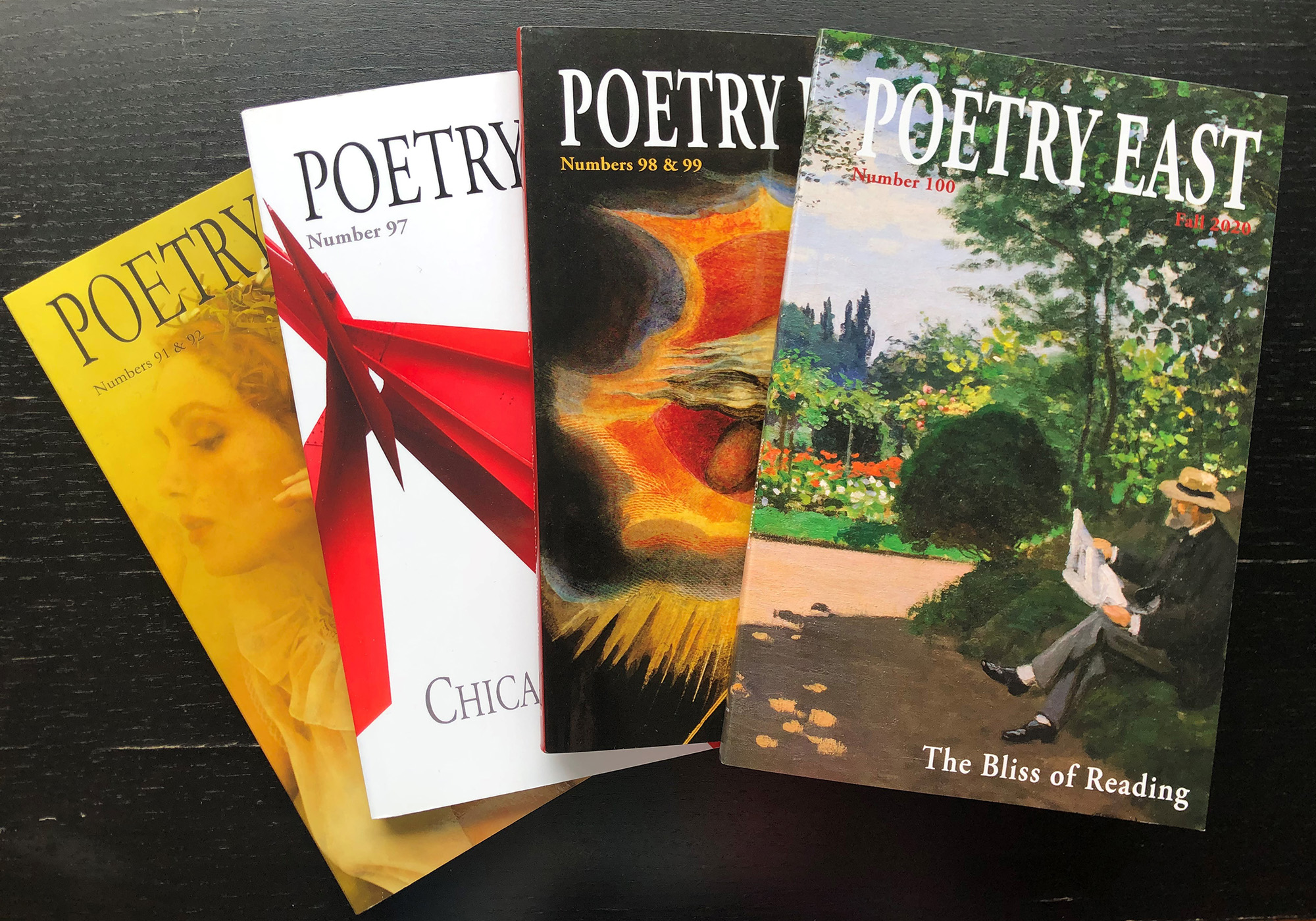 Hard copies of the Poetry East journal on a table