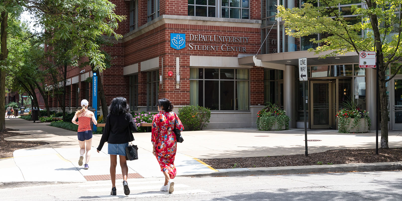 Two students walk across the street towards the DePaul Student Center.