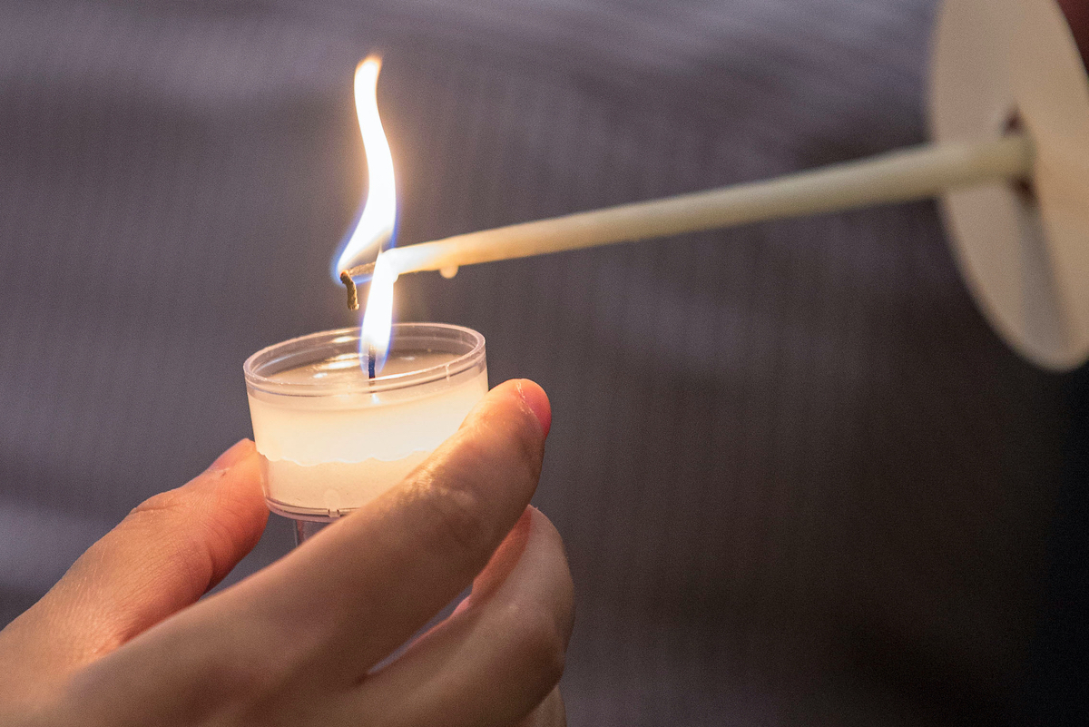 A candle is lighted during a vigil.