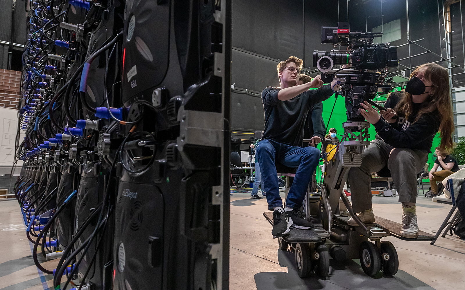 Two students operate a professional film camera on set at DePaul Cinespace