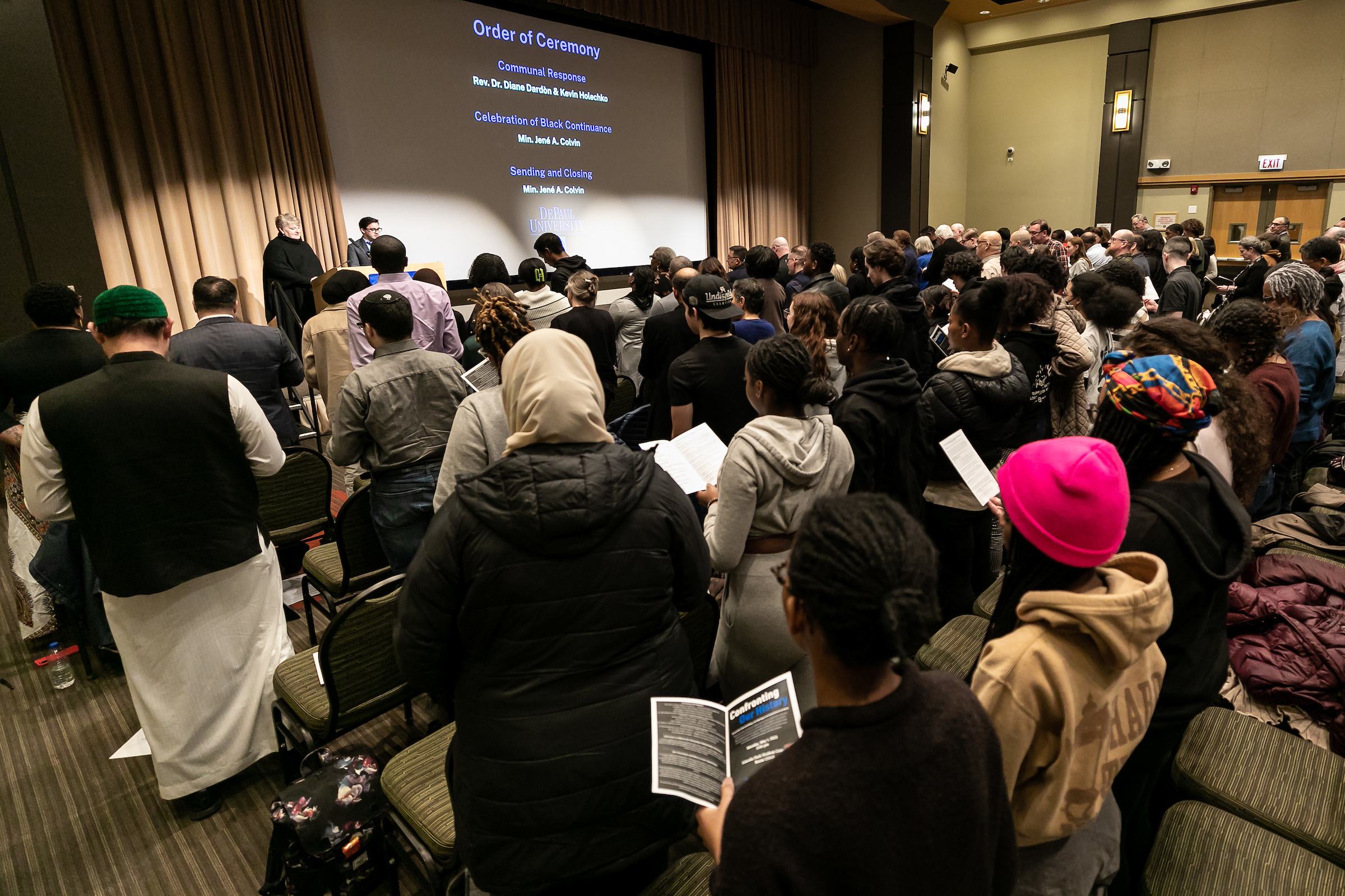 A group of people stand and speak together in the DePaul Student Center. 