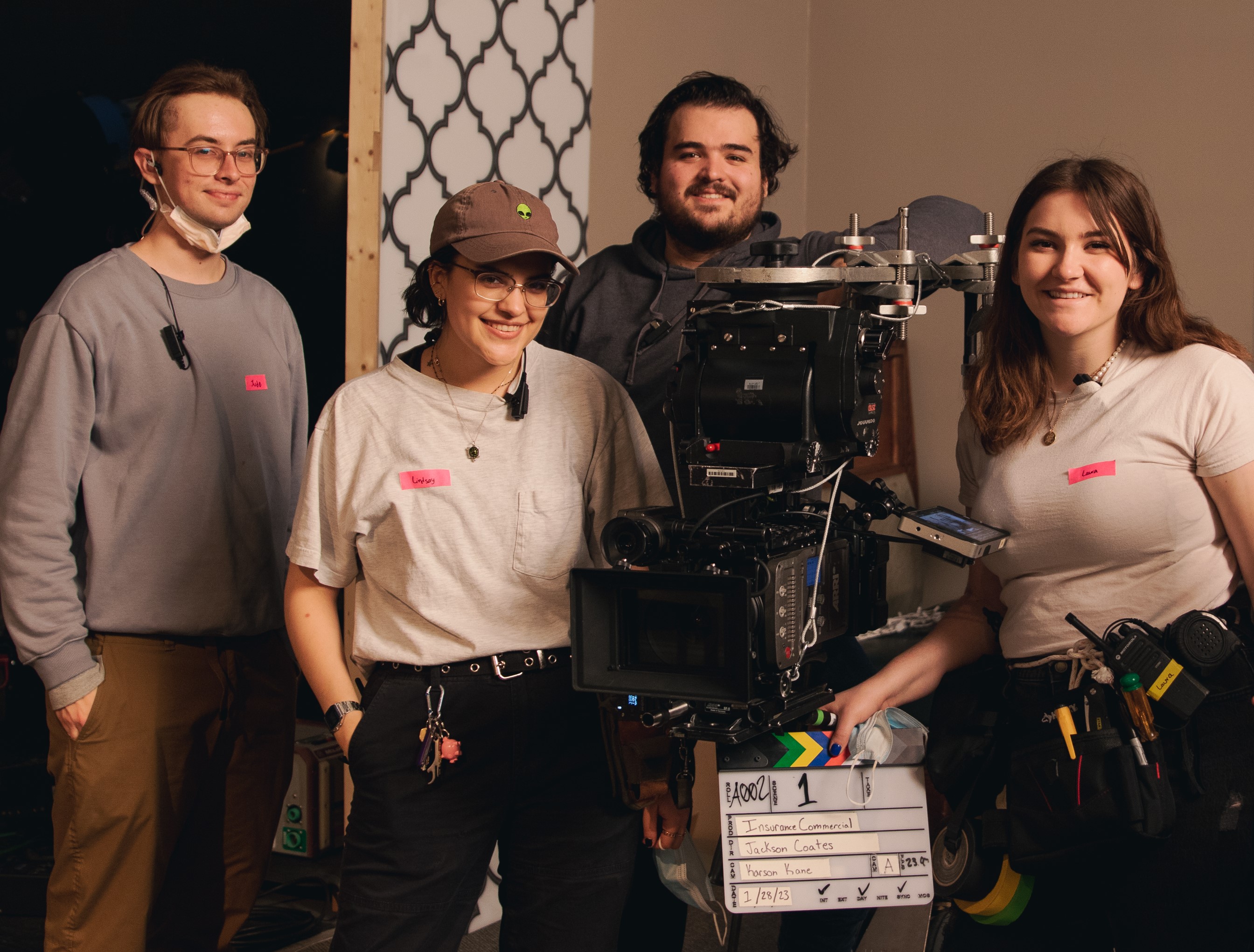 School of Cinematic Arts Students on set with a camera smiling