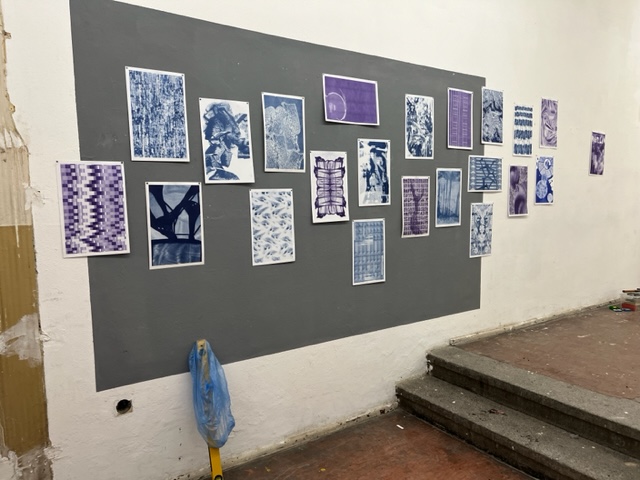 Many blue and purple abstract prints hanging on the wall