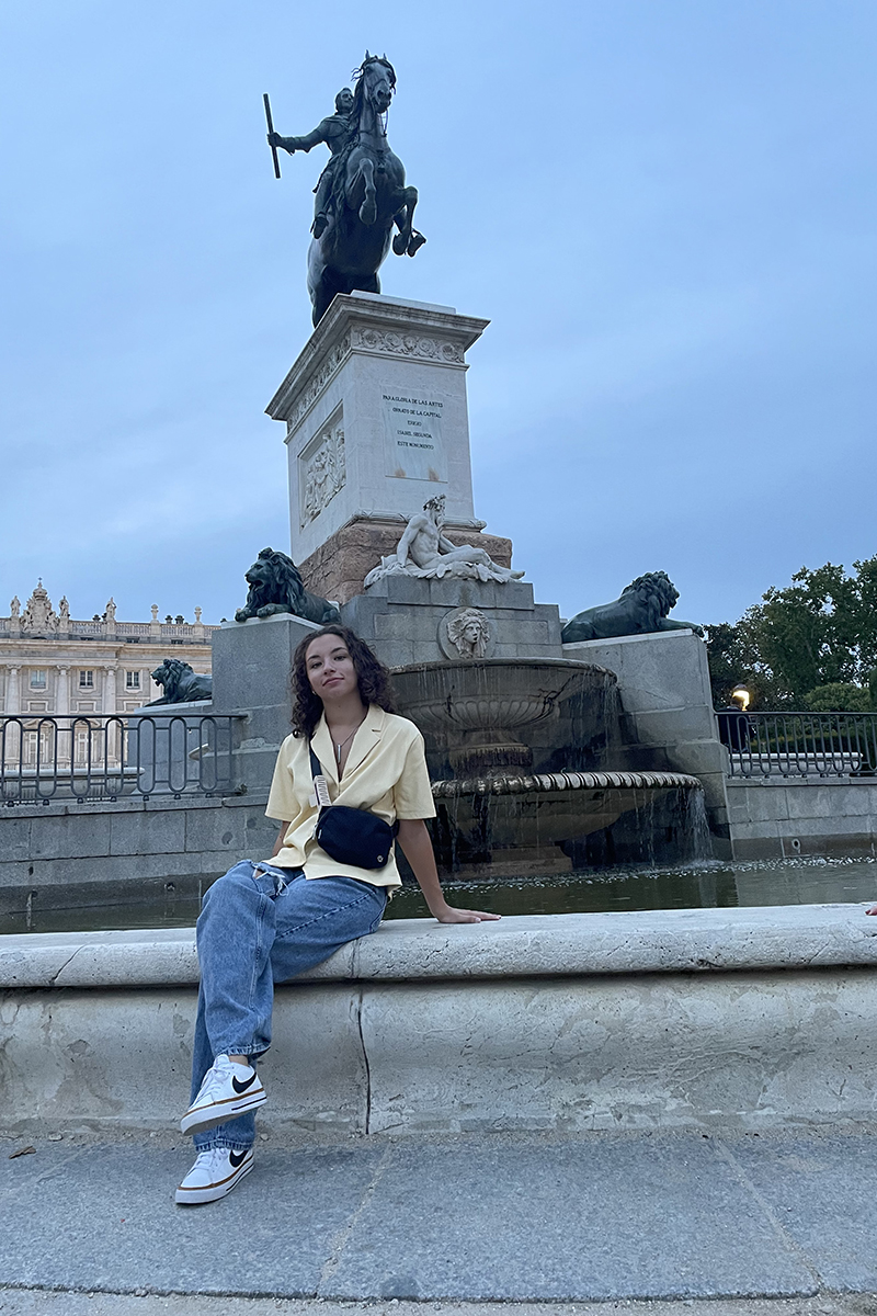 Fiorella O'Connor sits in front of a statue in Madrid