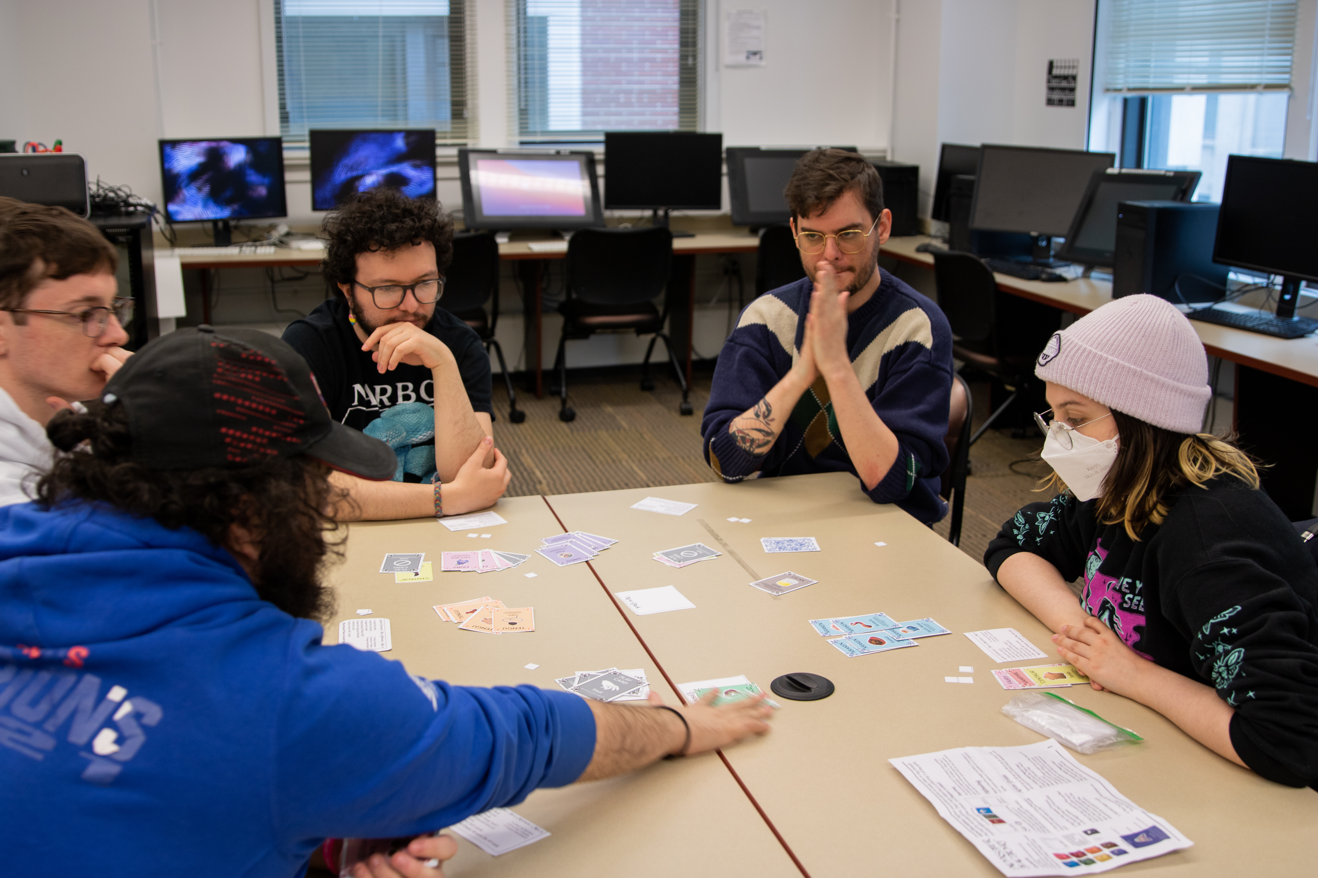 Students around a table play card games