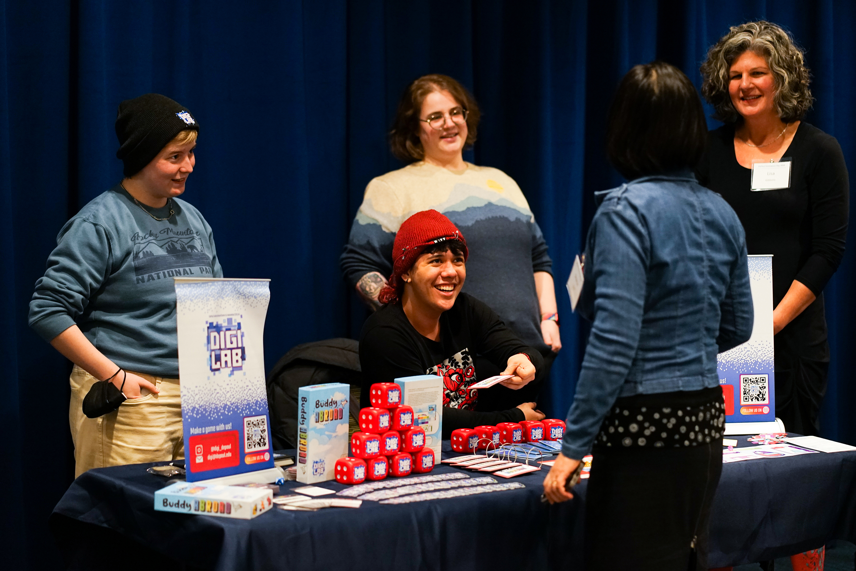 People smiling at a table with swag and a board game
