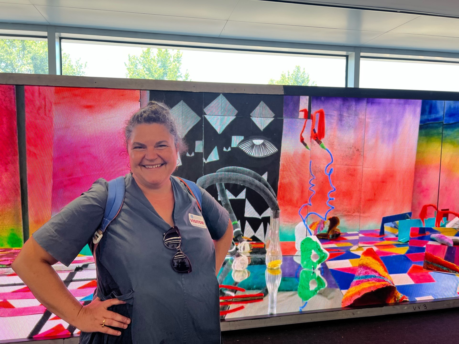 Selina Trepp smiling in front of her art piece for O'Hare airport