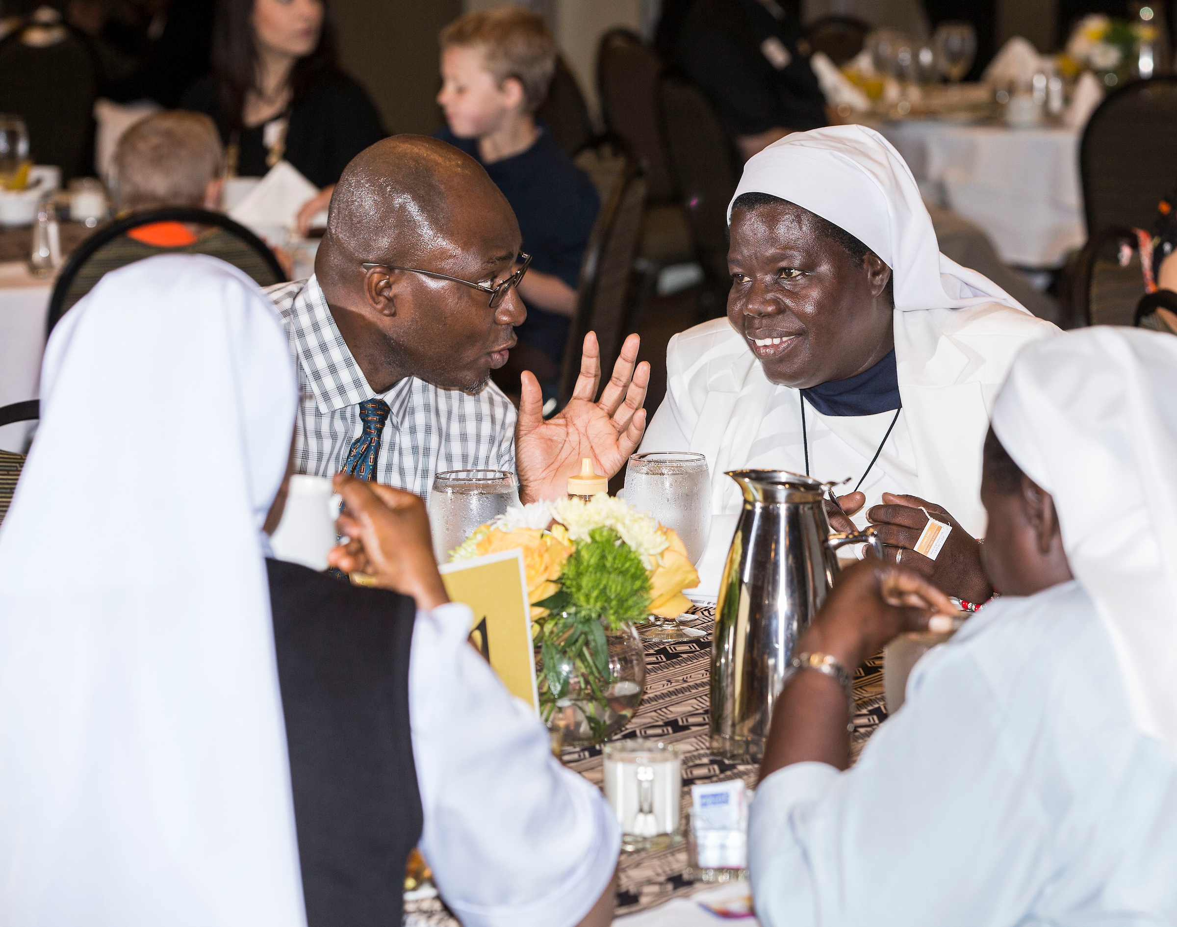 Father Stan Chu Ilo (left) chats with Sister Rosemary Nyirumbe during a breakfast at DePaul in 2015.