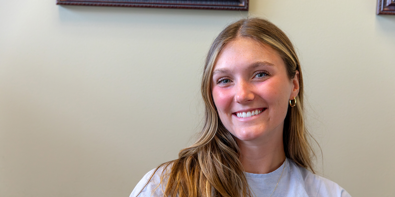 A woman sits smiling in an office