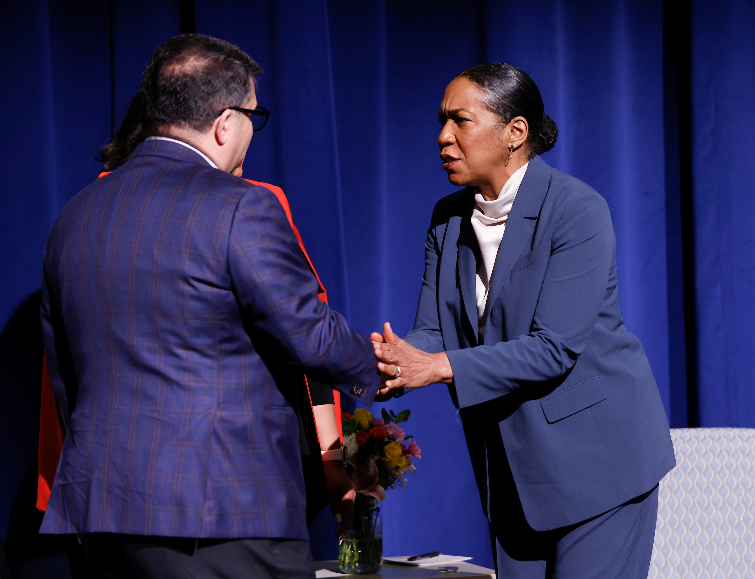 DePaul President Rob Manuel presents Illinois Lieutenant Governor Juliana Stratton with a DePaul Shared Coin, which is presented to individuals living DePaul's Vincentian Mission.