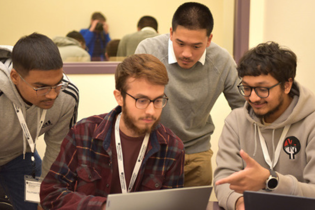 Four people working together on a computer