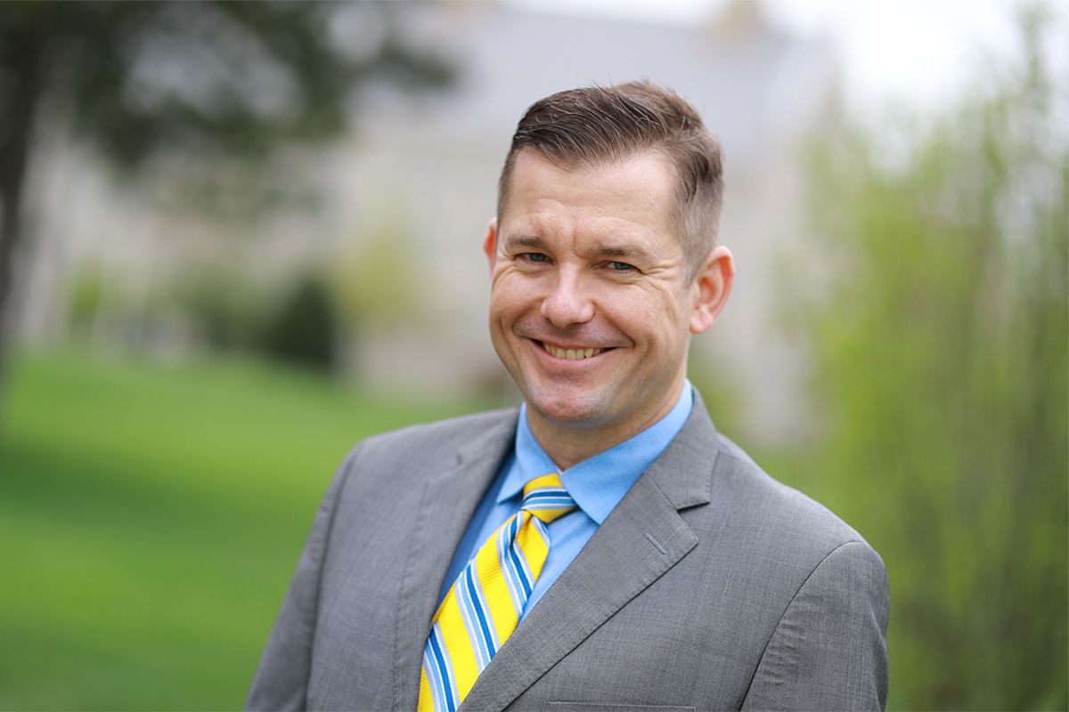 Man in suit smiles at the camera