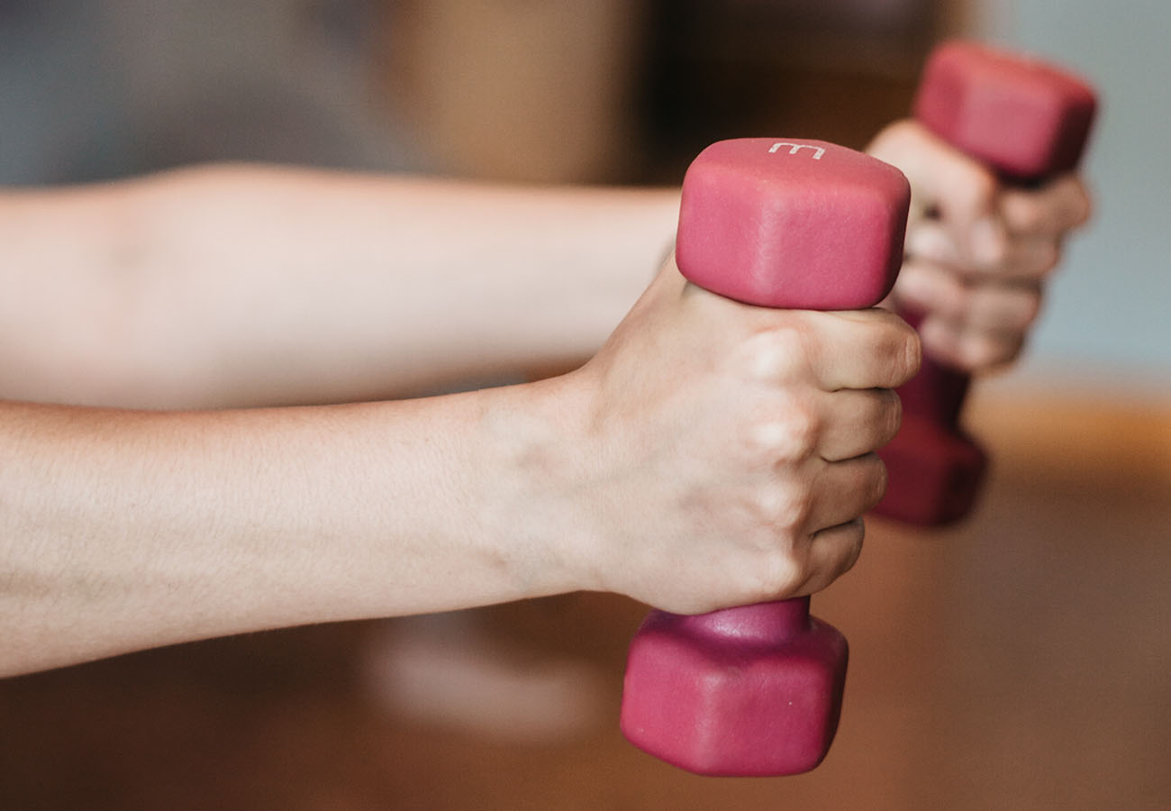 Hands holding two hand weights