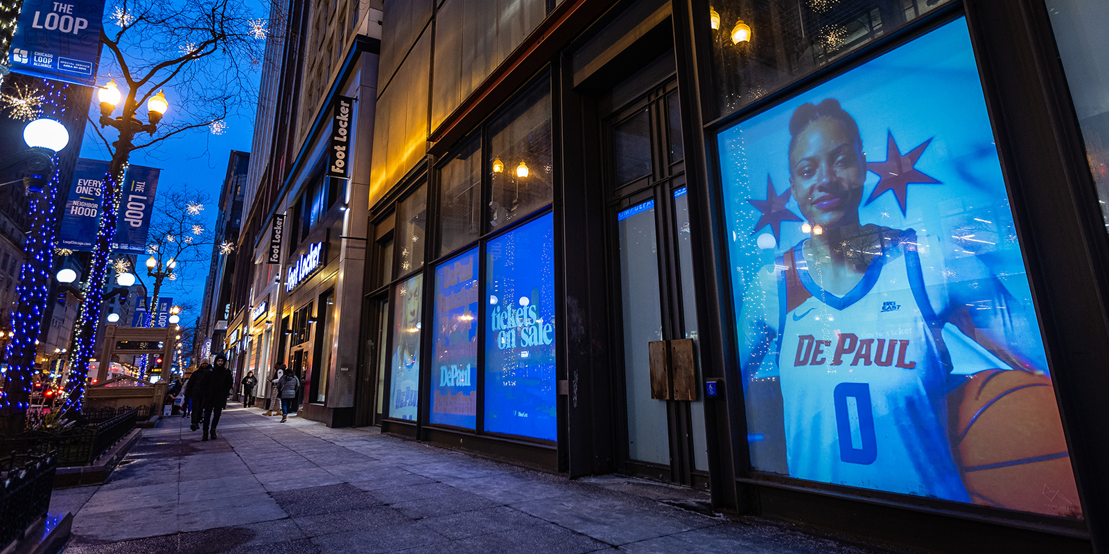 Images and videos of DePaul basketball players are displayed in a storefront on State Street
