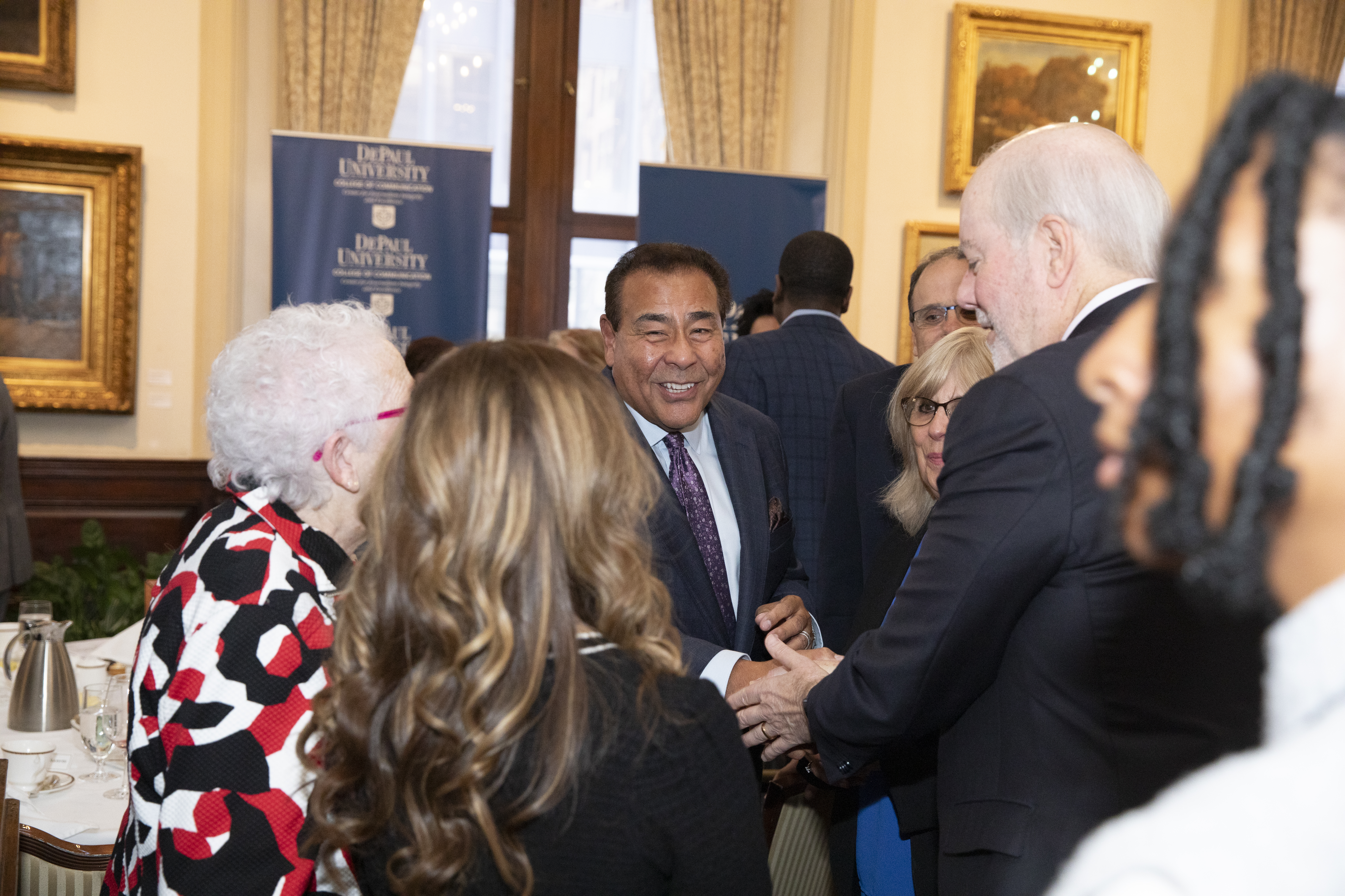 John Quiñones shakes hands with attendees