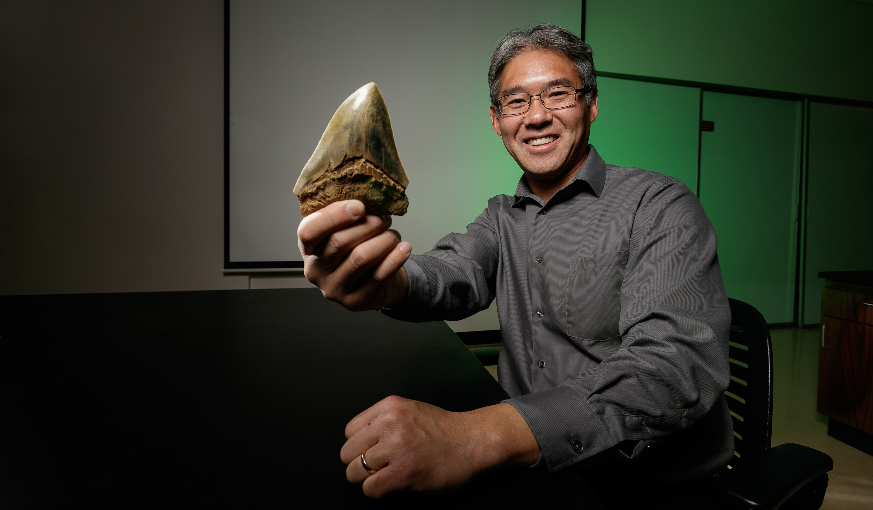 Kenshu Shimada holding a Megaladon shark tooth