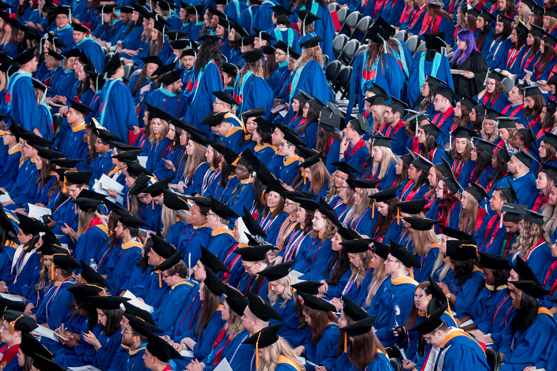 Crowd of graduates sit awaiting to receive their diploma 