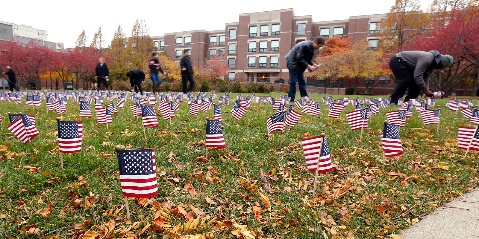 People line American flags on lawn of DePaul campus