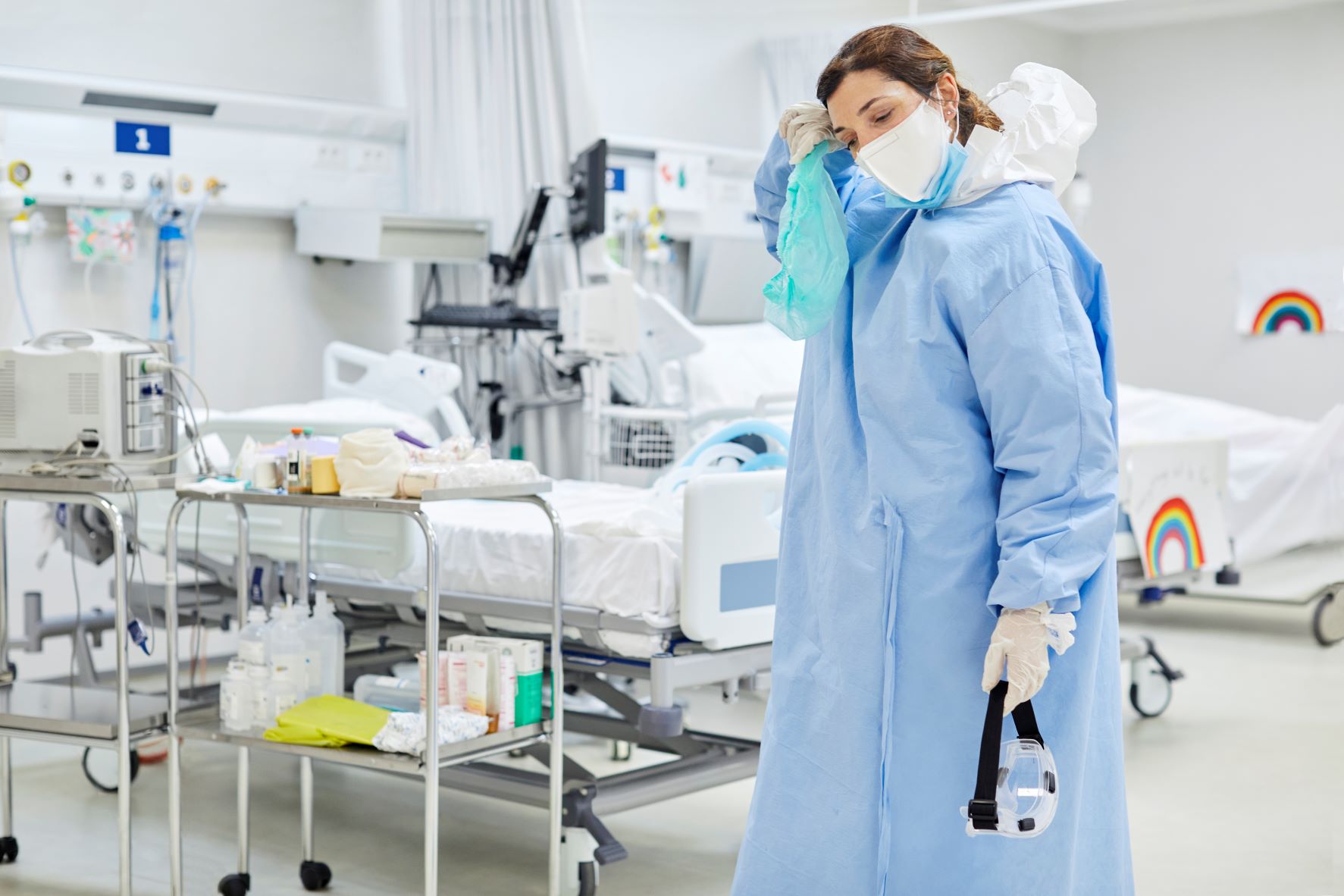 Exhausted nurse in PPE in hospital setting