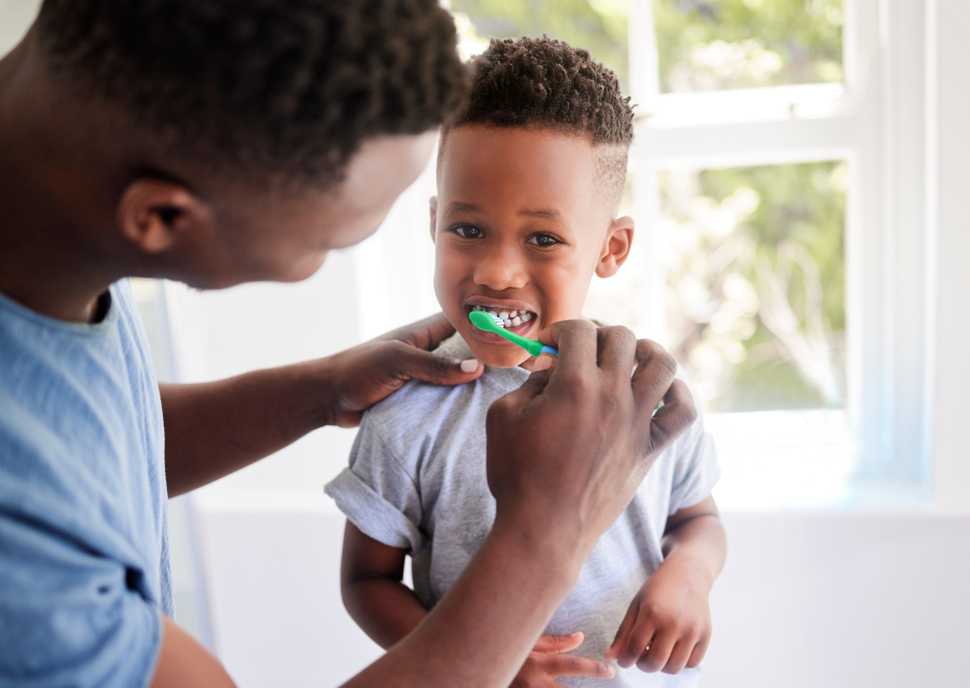 Parent brushing a child's teeth