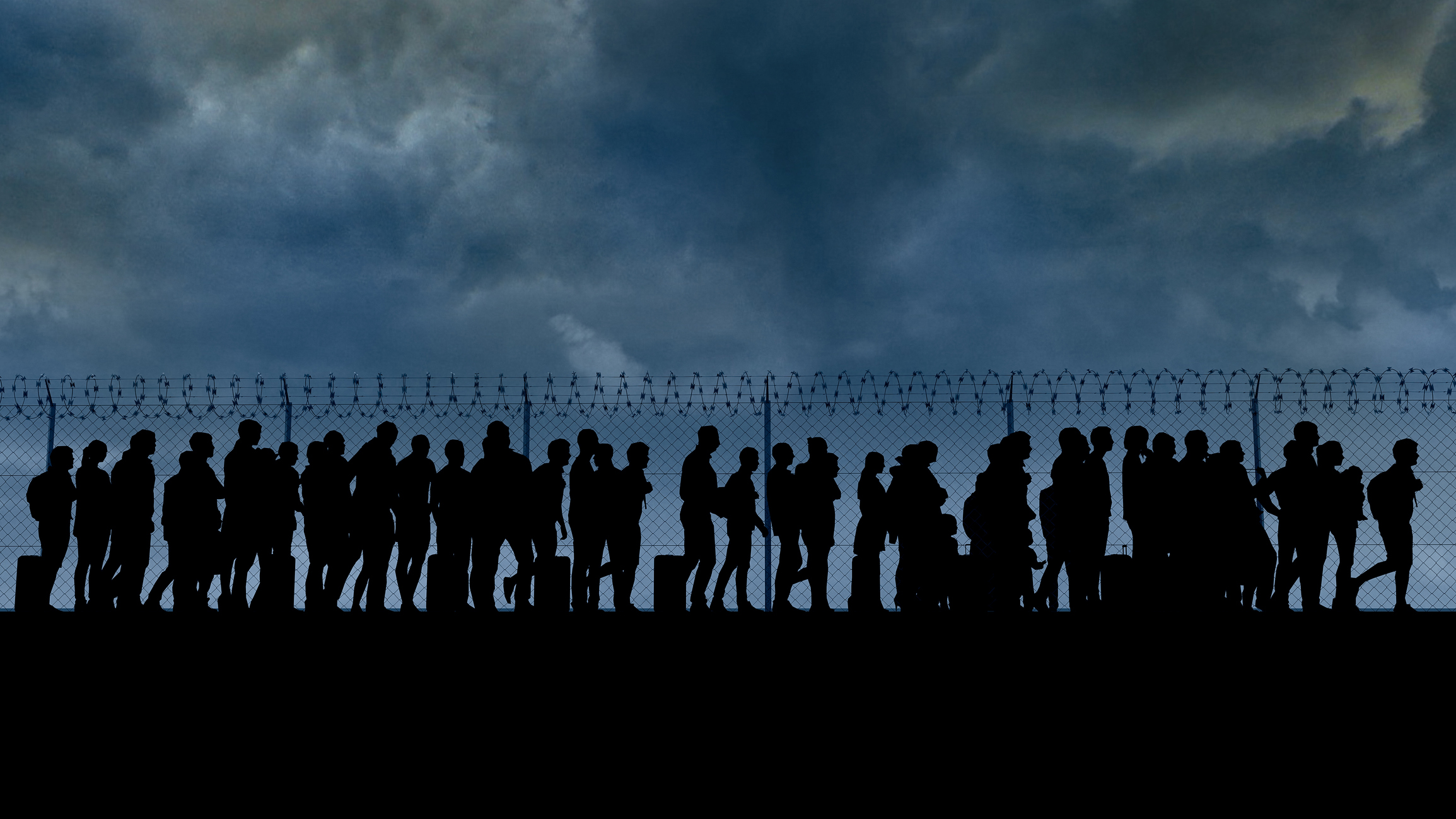 Immigrants behind a razor wire fence