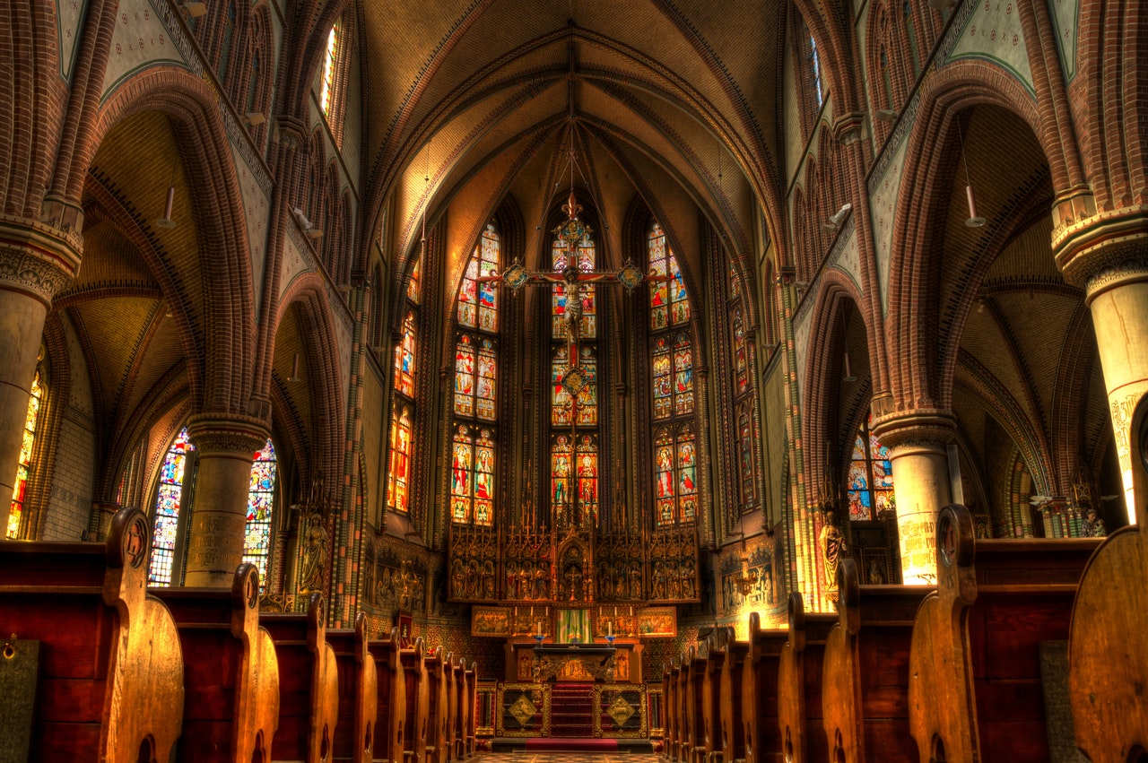 Church aisle ending in a large stained glass window.