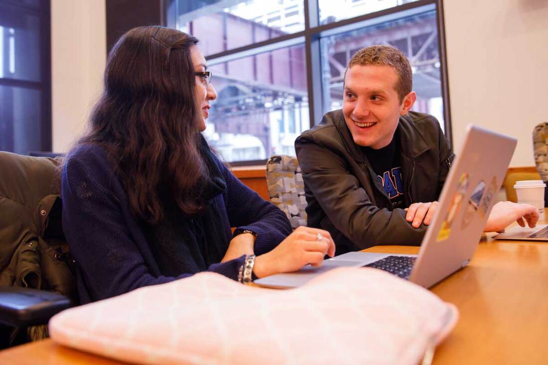 students talking in front of a computer