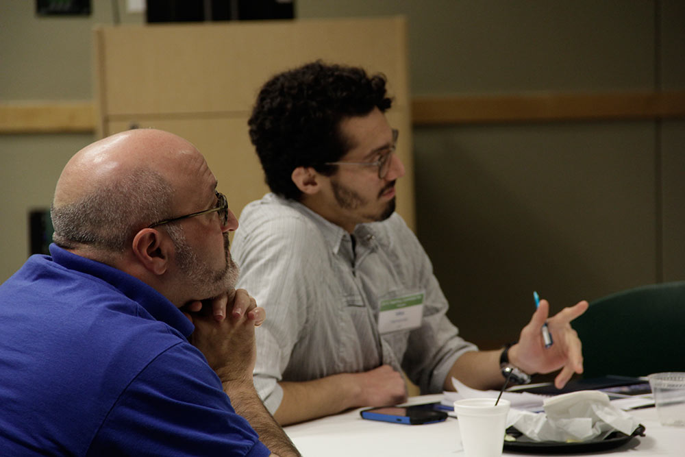 Two people listening to a speaker during a conference