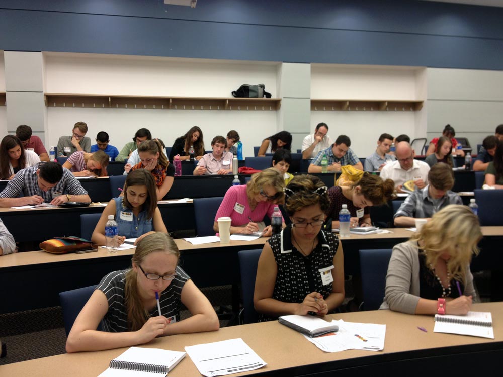 Students sitting in a classroom writing notes.