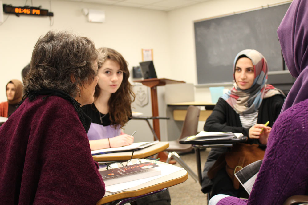 Students sitting in class listening to the professor speak.