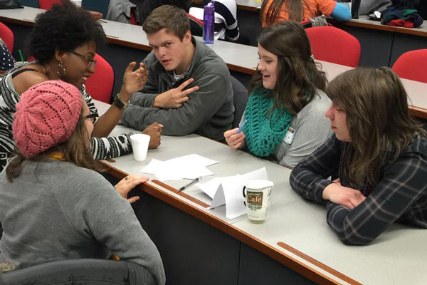 Students conversing in a classroom.